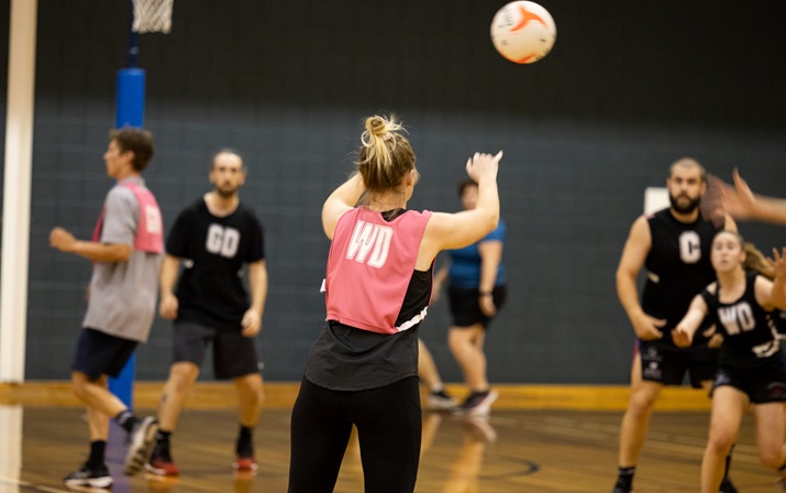 Rear view of netballer releasing a pass