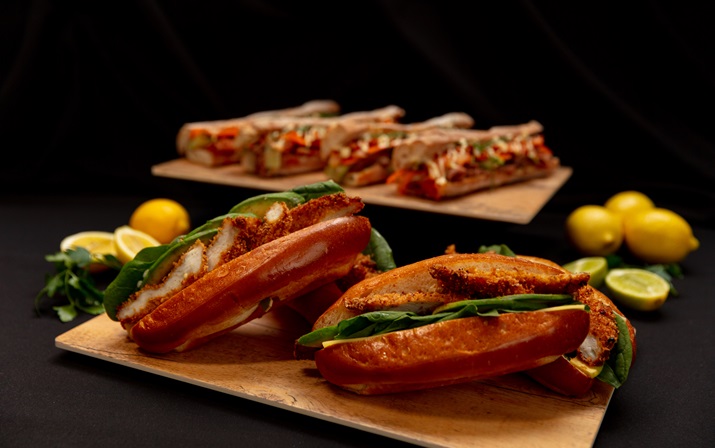 A staged photo of various sandwiches and food options posed