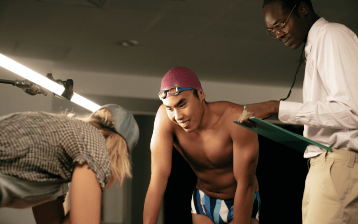 Close up, Josh Yong at the WAIS High Performance Service Centre in Mount Claremont, Perth Josh Yong wearing a swimming cap and goggles being tended to by two helpers with clipboards at the WAIS High Performance Service Centre in Mount Claremont, Perth