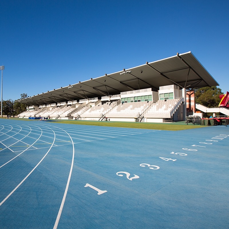 A photo of the blue running track at the WA Athletics Stadium